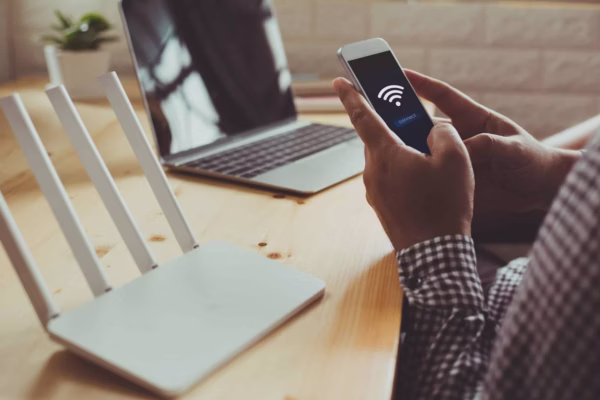Wireless router setup with smartphone and laptop in home or office SysPros technician performing a wireless network installation service for a home user.