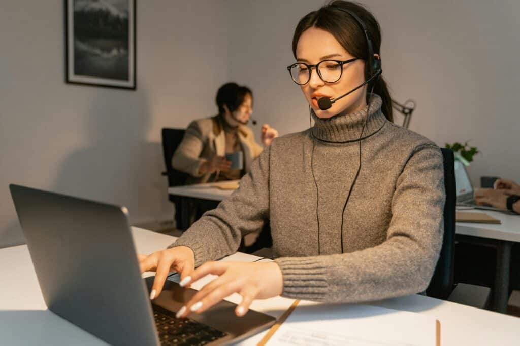Remote support technician wearing a headset providing support on a laptop.