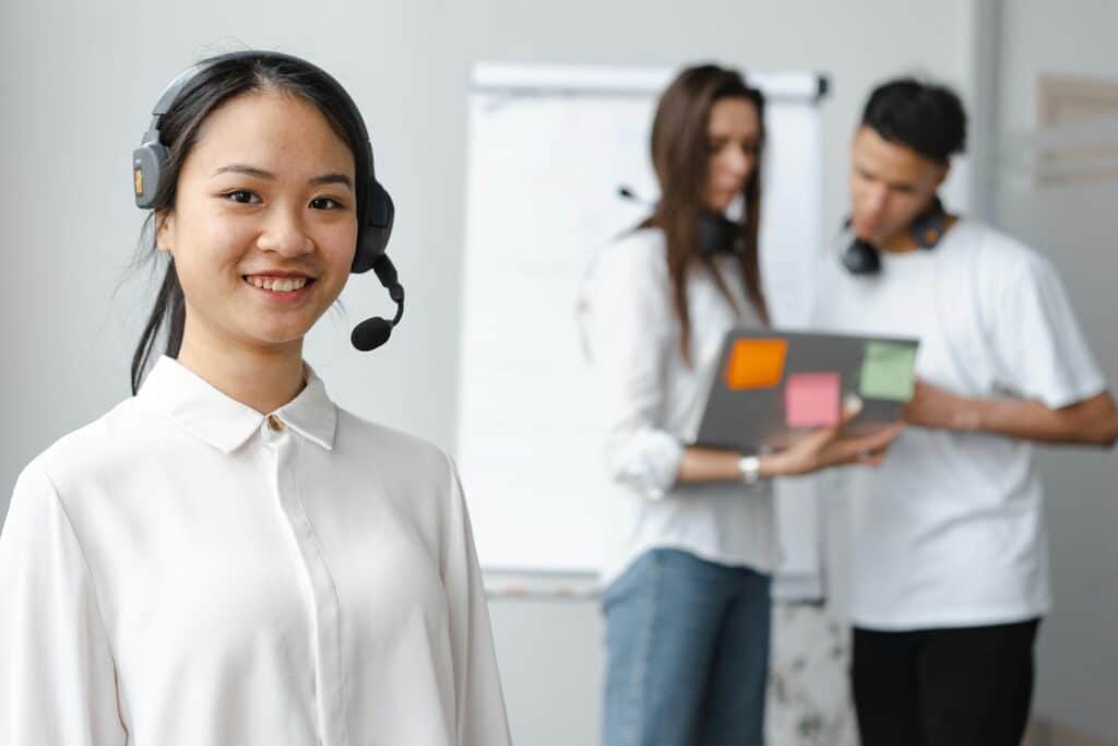 Remote support agents conversing around a laptop.
