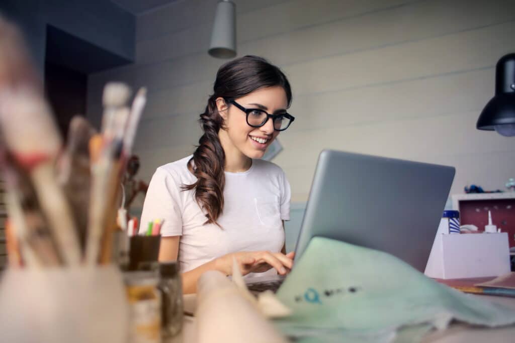 Smiling woman receiving IT support services while working on her laptop at home.