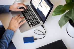 Laptop connected to external hard drive with file transfer in progress