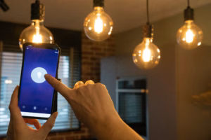 Person using smartphone app to control smart lighting in a modern home